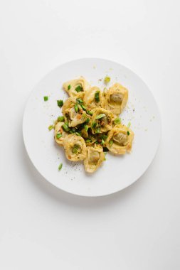Beyaz arka planda tereyağı soslu Tortellini makarna..
