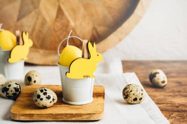 Paskalya masa dekorasyonu. Yakın plan. Sarı mum yumurta, tavşan ve bıldırcın yumurtası..