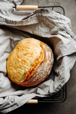 Koyu arkaplanda havluyla taze pişmiş ekmek..