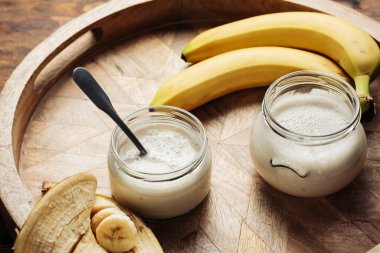 Tahta tepside iki kavanoz muzlu yoğurt.