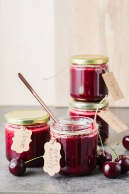 Küçük kavanozlarda ev yapımı kiraz reçeli ve taze kiraz..