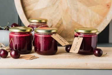 Masadaki küçük kavanozlarda kiraz reçeli. Ev konservesi.