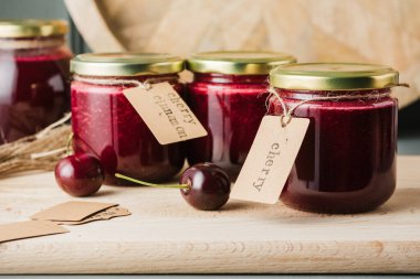 Masadaki küçük kavanozlarda kiraz reçeli. Ev konservesi.