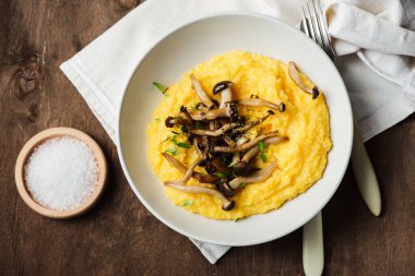 Creamy polenta with roasted shimeji mushrooms, top view. clipart