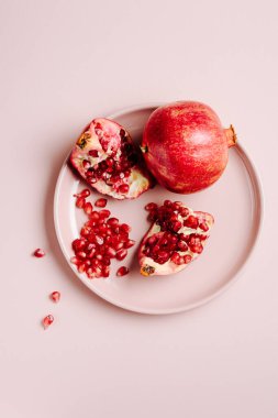 Nar ve tahıl. Pembe arka planda olgun nar parçaları..