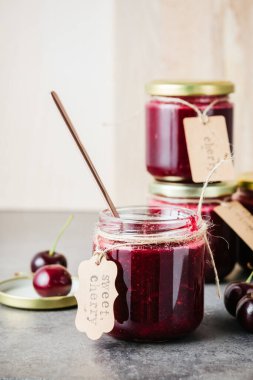 Küçük kavanozlarda ev yapımı kiraz reçeli ve taze kiraz..