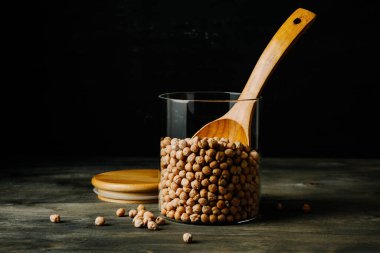 Karanlık bir arka planda bir kavanoz nohut fasulyesi..