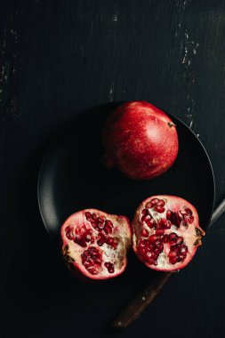 Koyu arkaplanda taze kesilmiş nar..