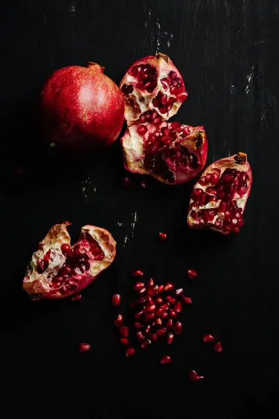 Olgun nar ve koyu arkaplanda taneler.