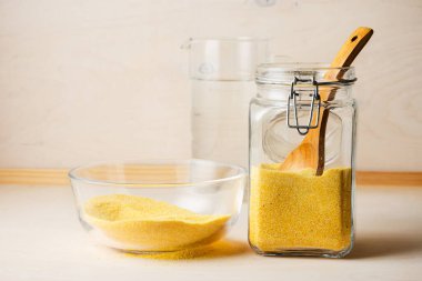 Tahta bir masada cam bir kavanozda mısır ezmesi..