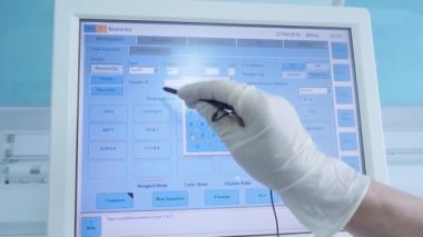 Test tüpleri olan laboratuvar test makinesi ve bilgisayar HD üzerinde veri ayarlayan laboratuvar asistanı