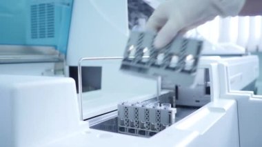 Laboratuvarda yapılan araştırmalara göre, tıbbi görevli kan ve idrar örnekleriyle test tüpleri yerleştiriyor. Tıbbi testler. Klinik teşhis tıbbı