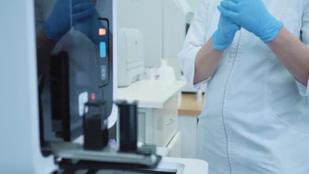 专业医学研究 一位实验室工作者的医学科学家正在把试管的血镜植入生化分析仪 — 图库视频影像