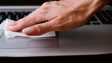 Ofis temizliği. Bir dizüstü bilgisayarı peçeteyle silmek