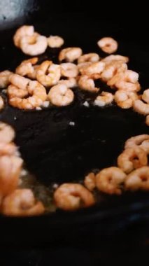 Yemek tarifleri. Deniz ürünleri. Kızartma tavasında karides. Yemek pişirmek. Sağlıklı yiyecek. Dikey video.