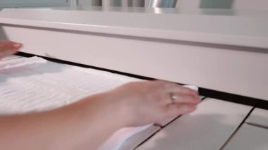 Çamaşır işçisi temiz çamaşırları endüstriyel bir ütüyle ütülüyor. Yıkama