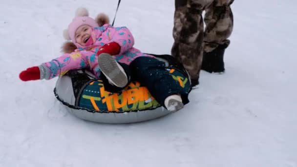 冬のレクリエーションとエンターテイメント 子供が雪の中でチューブしている — ストック動画