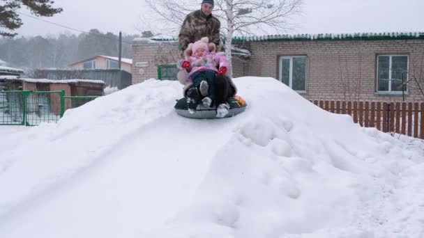 Téli Kikapcsolódás Szórakozás Egy Gyerek Nagymamája Szánkóznak Egy Dombról — Stock videók