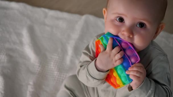 ポップして 小さな女の子は新しい感覚のおもちゃで遊んでいます 虹です 子供と大人のためのアンチストレス玩具 — ストック動画