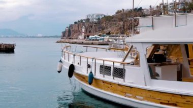 Beyaz bir yat kıyıya demirlemiş. Güney kıyısında bir liman. Turistik yer