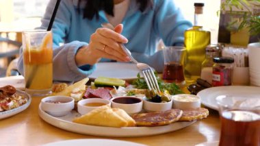  Bir kafede kahvaltı yapmak. Yumurtalı, krepli ve zeytinli lezzetli yemekler.