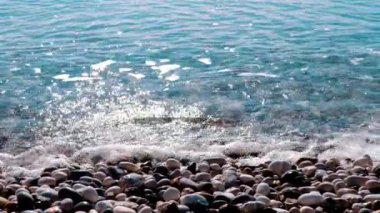 Deniz dalgaları büyük çakıl taşlarının üzerinde yuvarlanacak. video için deniz arkaplanı