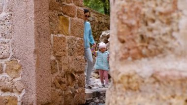 Anne ve bebek taş duvarlar boyunca yürüyorlar. Turistik yerler