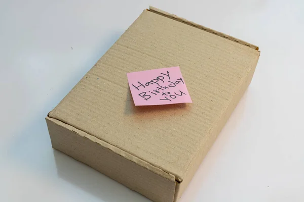 幸せな誕生日のテキストメモが付いた小包ボックス付箋に書かれている — ストック写真