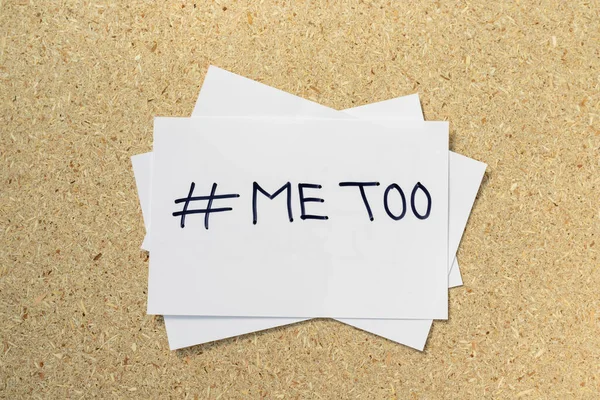 The METOO movement against sexual harassment at work hand written on a white card with corkboard background with copy space