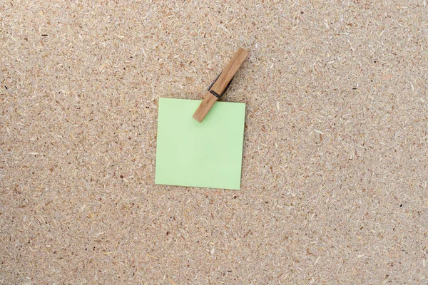 stock image Blank sticky notes clip with a clothespin on a cork board background