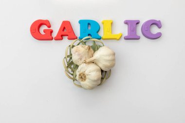 Beyaz izole arkaplanda minyatür sepetinde sarımsak ampulleri.