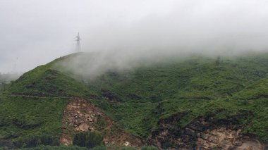 Pakistan 'daki SWAT Vadisi' nde, yamaçtaki yeşil bir dağın üzerinde sis var.