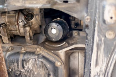 Atölyede araba yağı filtresi değiştiriliyor