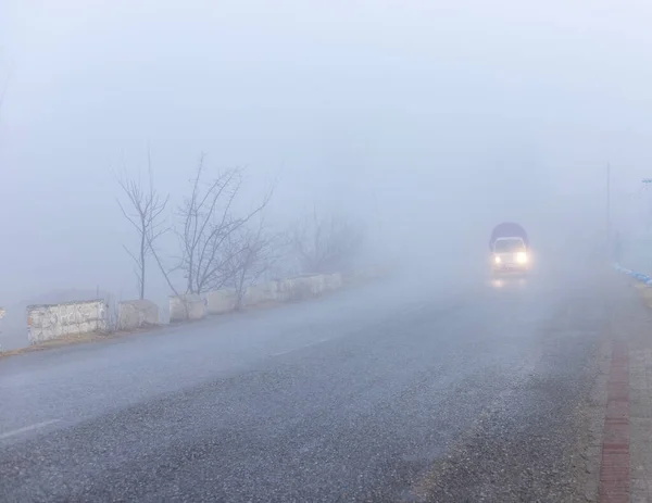 Low traffic on a road in a foggy weather with low visibility