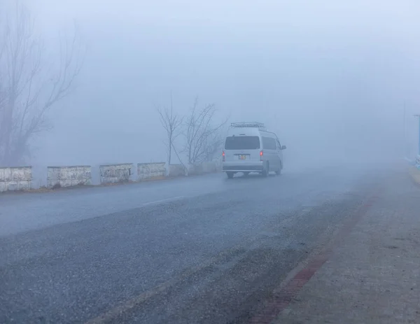 Winter tourism in swat valley, coach on a road in fog