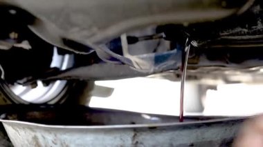 Yağ değiştirme işlemi sırasında bir aracın motorundan akan kirli motor yağı. seçici odak