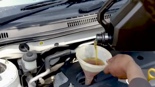 机械地将汽车发动机机油倒入手握的发动机漏斗中 — 图库视频影像