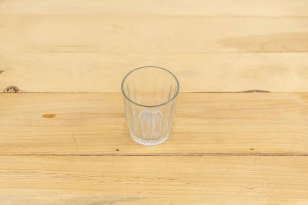 stock image Empty glass for water on a wooden table. selective focus