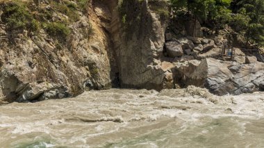 Nehirdeki çamurlu su boyunca akan taze temiz su.