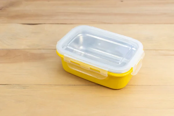 木制桌子特写镜头上的黄色食品容器 — 图库照片