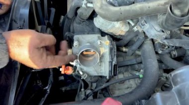 Bir arabanın gaz pedalı tamir ediliyor.