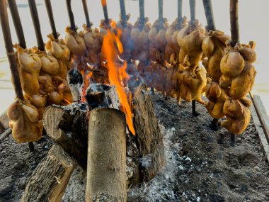 A traditional Balochi chicken Sajji is made in an open fire in Pakistan clipart