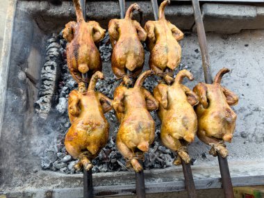 Making Balochi chicken sajji on charcoal grill clipart