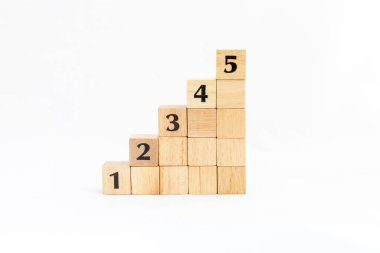 Tahta bloklar bir, iki, üç, dört ve beş numaralı merdivenlerle üst üste diziliyor. Büyüme ve başarı süreci için iş kavramı.