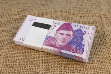 Pakistani 50 Rupee Banknotes Bundle on Burlap with Copy Space clipart