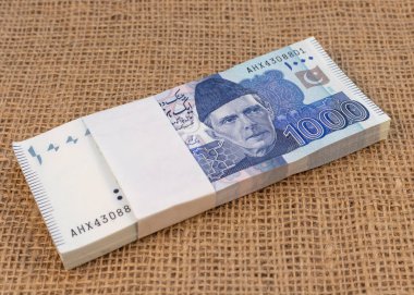 Çuval Bezi Arkaplanına Kopyalama Boşluğu ile Bin Rupi Banknotları Paketi