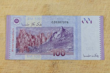 Tahta bir arka planda 100 halka şeklinde notun arkasındaki Gunung Api Vadisi 'nin kaya oluşumları: Pakistan - 26 Temmuz 2024.