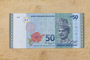 Ahşap bir zemin üzerinde mavi ve yeşil renkli Malezya 50 halka banknotu: Pakistan - 26 Temmuz 2024.