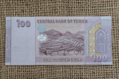 Yemen yüz (YRI 100) rial kırmızı ve mor banknot ters yüz tarımsal tarım arazileri ve Kraliçe Arwa camii mihrab nişanlı nikhe.