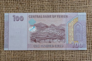 Yemeni one hundred (YRIs 100) rial red and violet banknote reverse features terraced agricultural farming fields and Queen Arwa mosque mihrab decorated niche. clipart